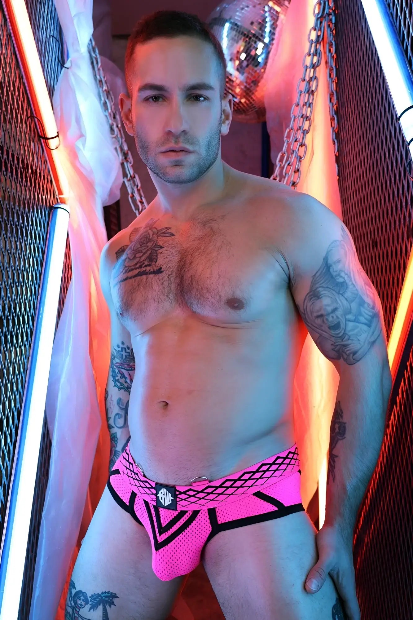 Bright pink mesh Revolution Brief with black trim and geometric pattern featuring a small front logo