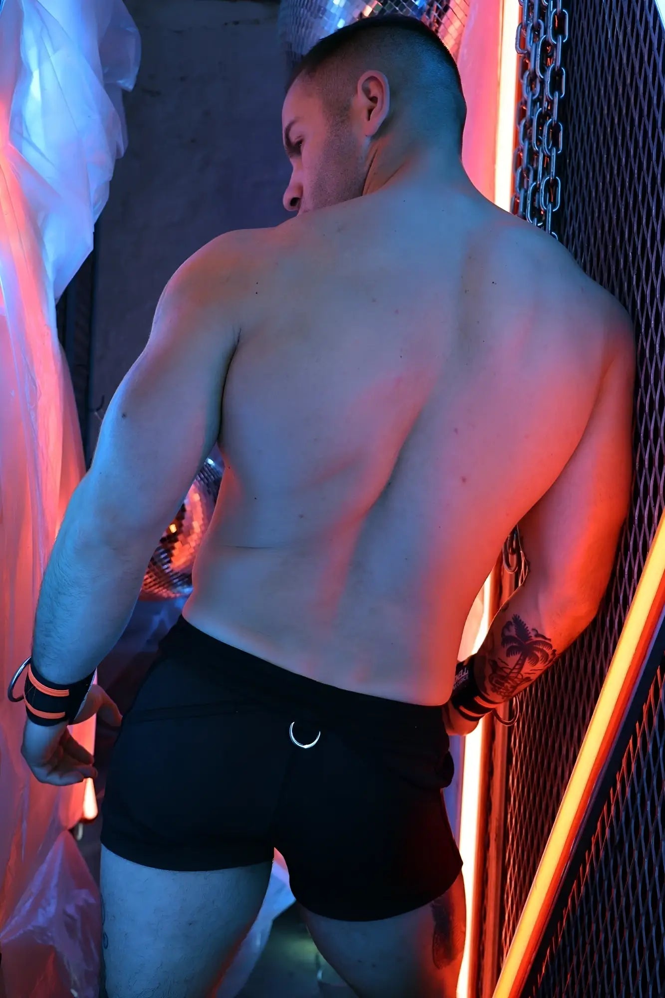 Back view of black Revolution athletic shorts with silver crescent moon logo on the back waistband