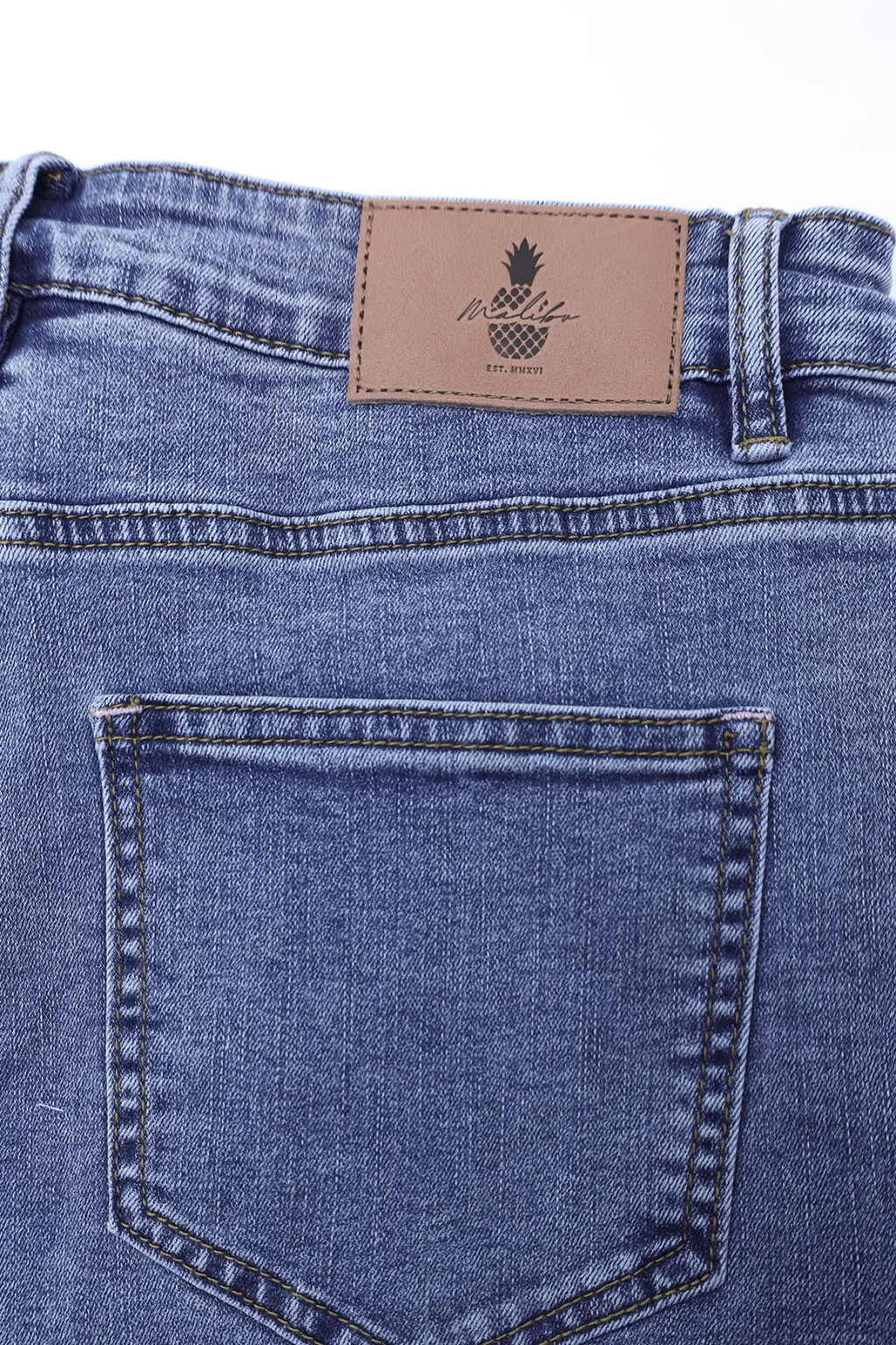 Blue denim rockstar raw cut 2.5 inch short shorts with brown leather patch featuring pineapple logo and mcllif branding
