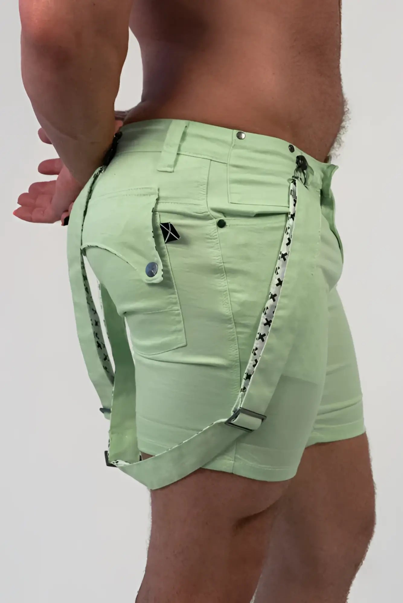 Romey shorts in light green with black star-patterned straps and a small black logo on the front pocket