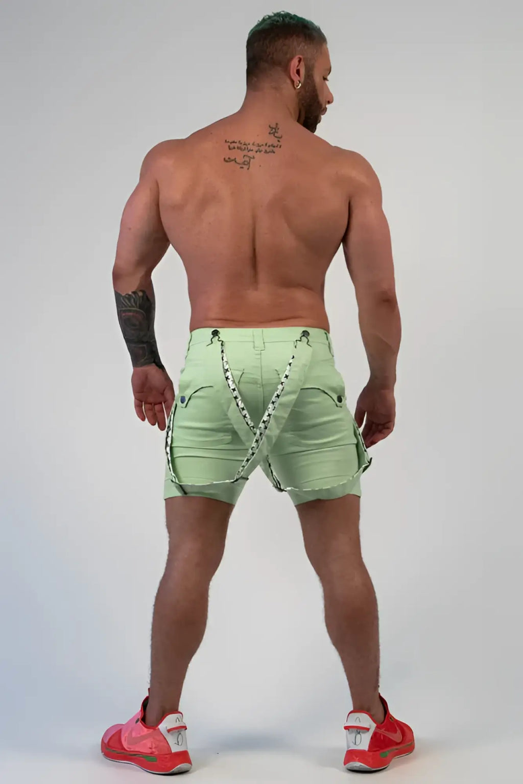 Back view of romey shorts light green cargo shorts with black and white patterned straps across the back