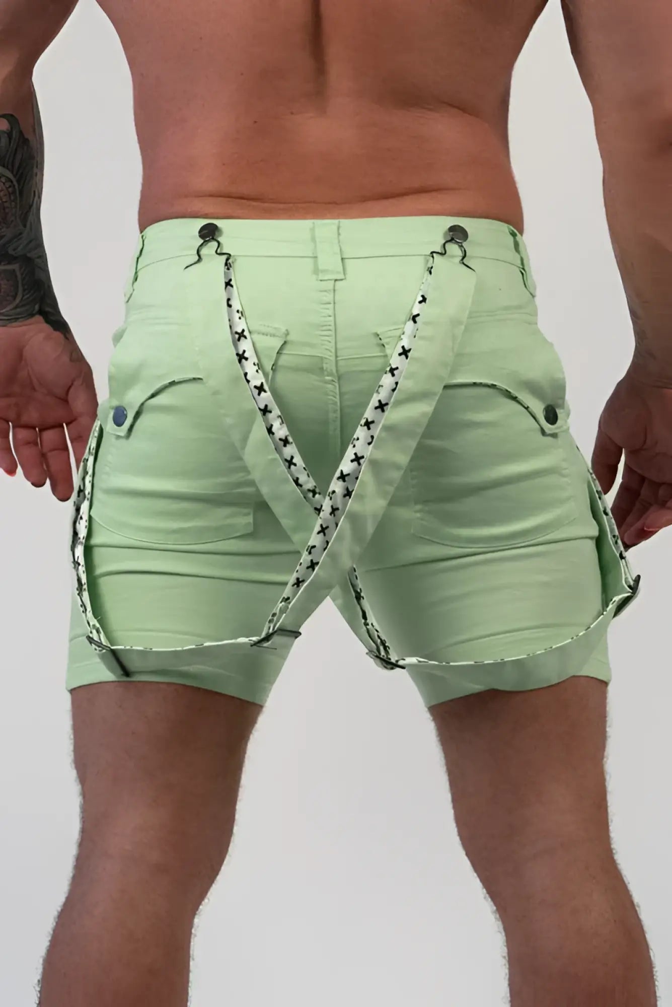 Light green denim romey shorts with black and white star-patterned suspenders front view