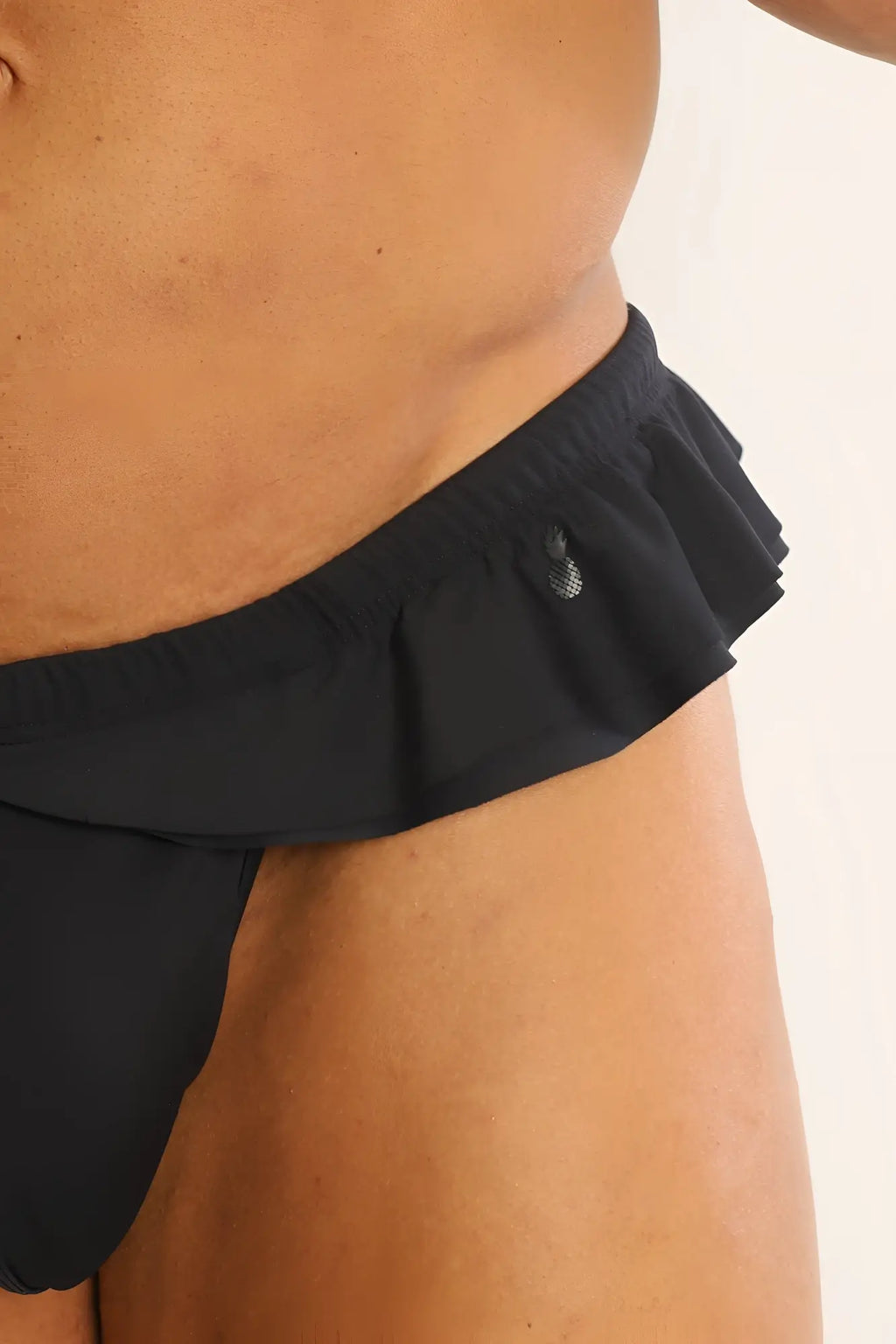 Black ruffle-trim athletic hybrid swim thong with textured logo on waistband designed for active beachwear