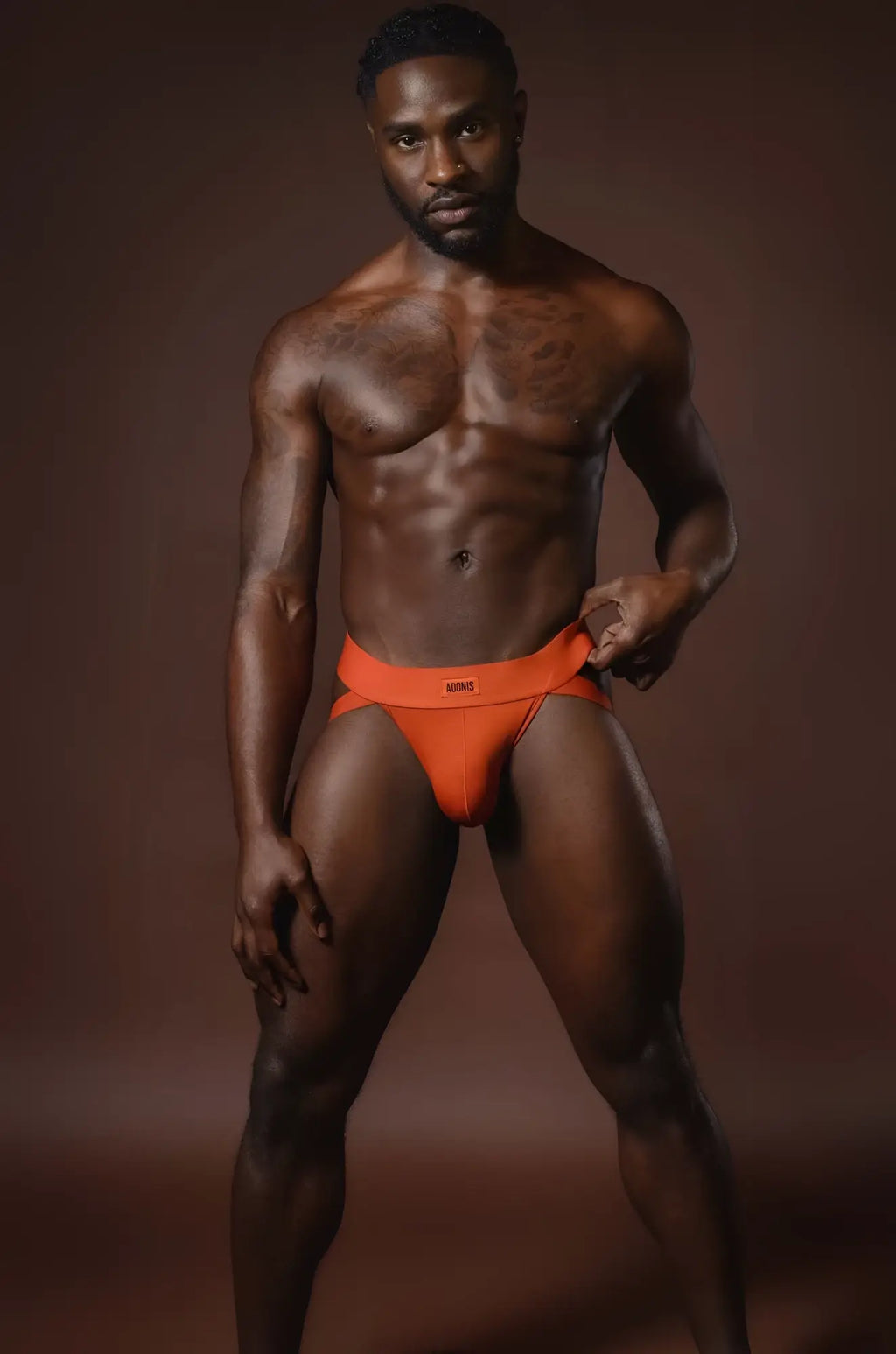 Rust orange jockstrap featuring bright orange briefs with a small rectangular logo on the waistband