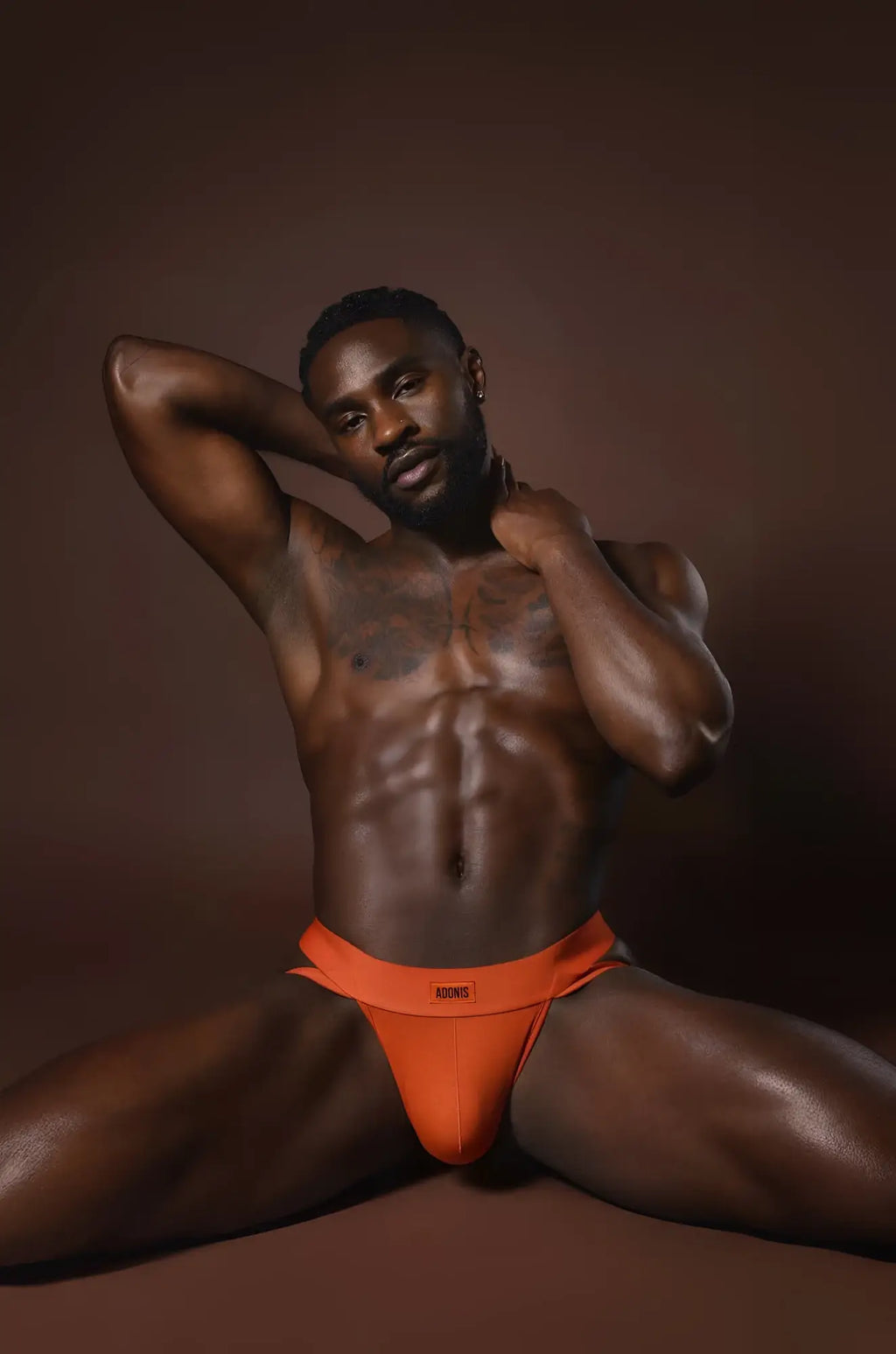 Bright orange rust orange jockstrap with form-fitting briefs and subtle logo on the waistband front side