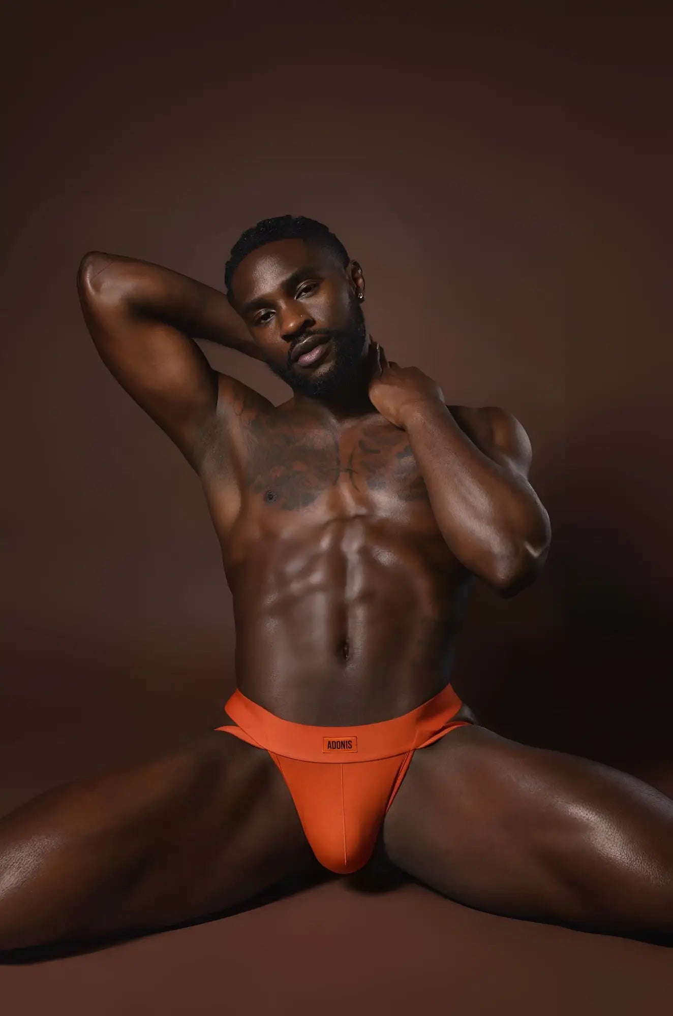 Bright orange rust orange jockstrap with form-fitting briefs and subtle logo on the waistband front side