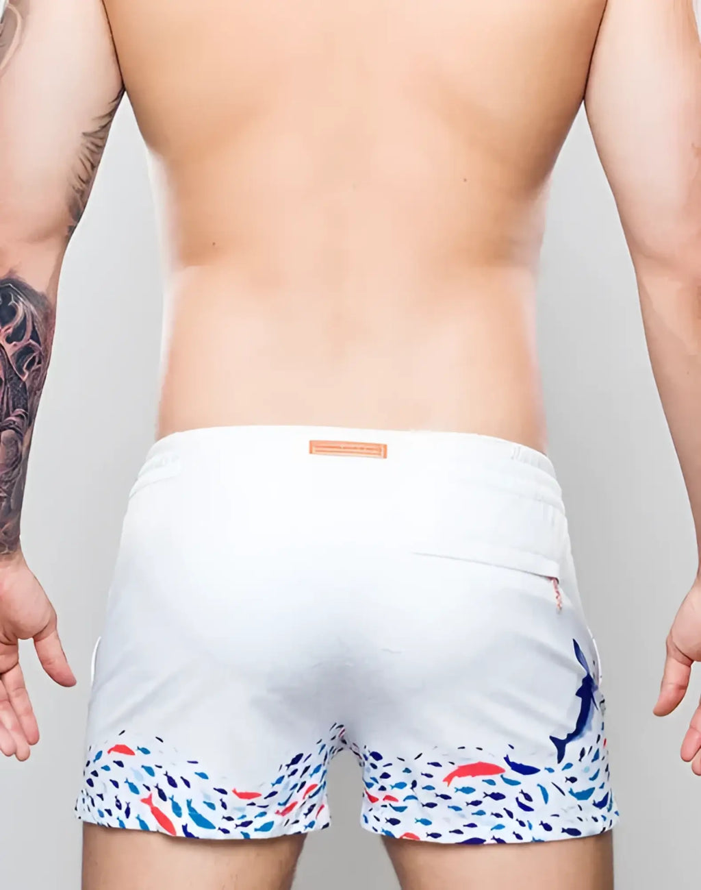White s50 seascape print swim shorts with colorful fish pattern on hem and side and subtle blue dolphin on right leg