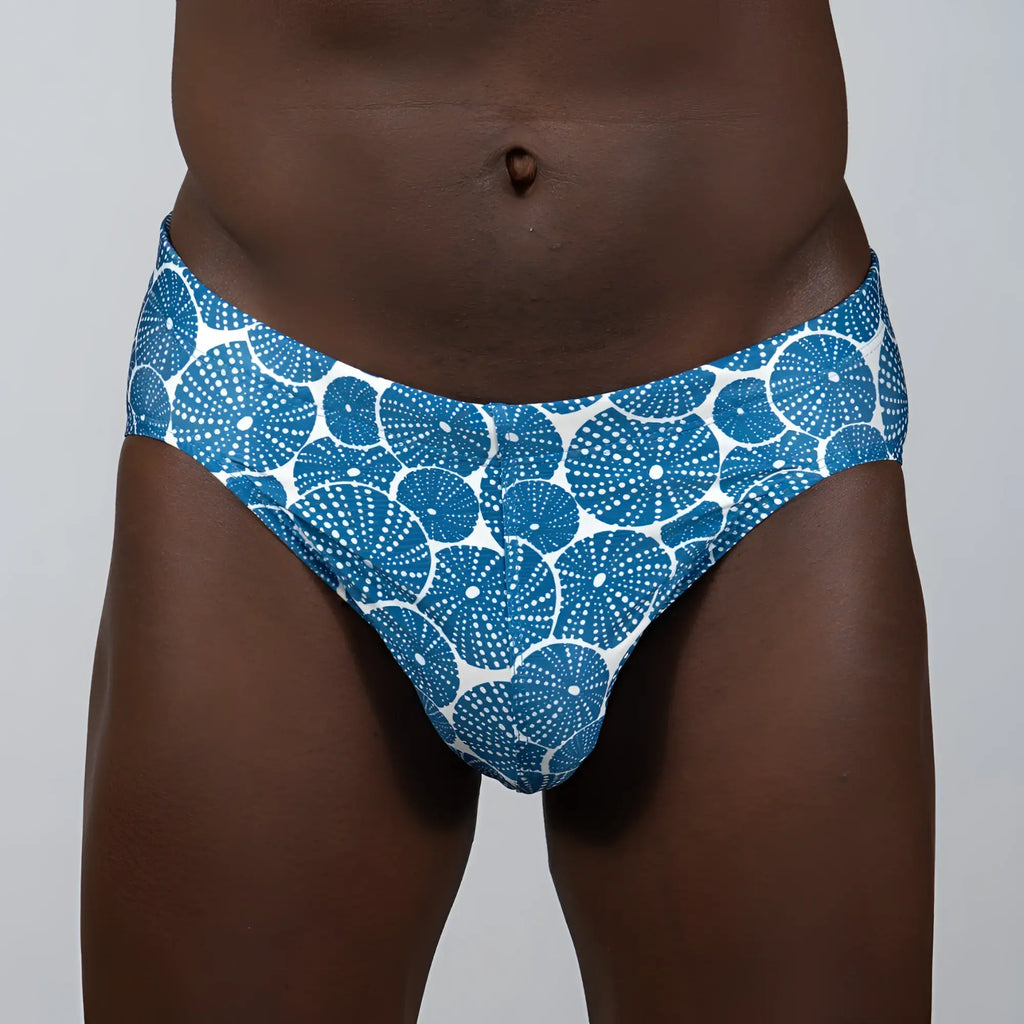 Blue and white patterned swim trunks featuring a repeating circular dotted motif called sand dollar brief