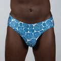 Blue and white patterned swim trunks featuring a repeating circular dotted motif called sand dollar brief