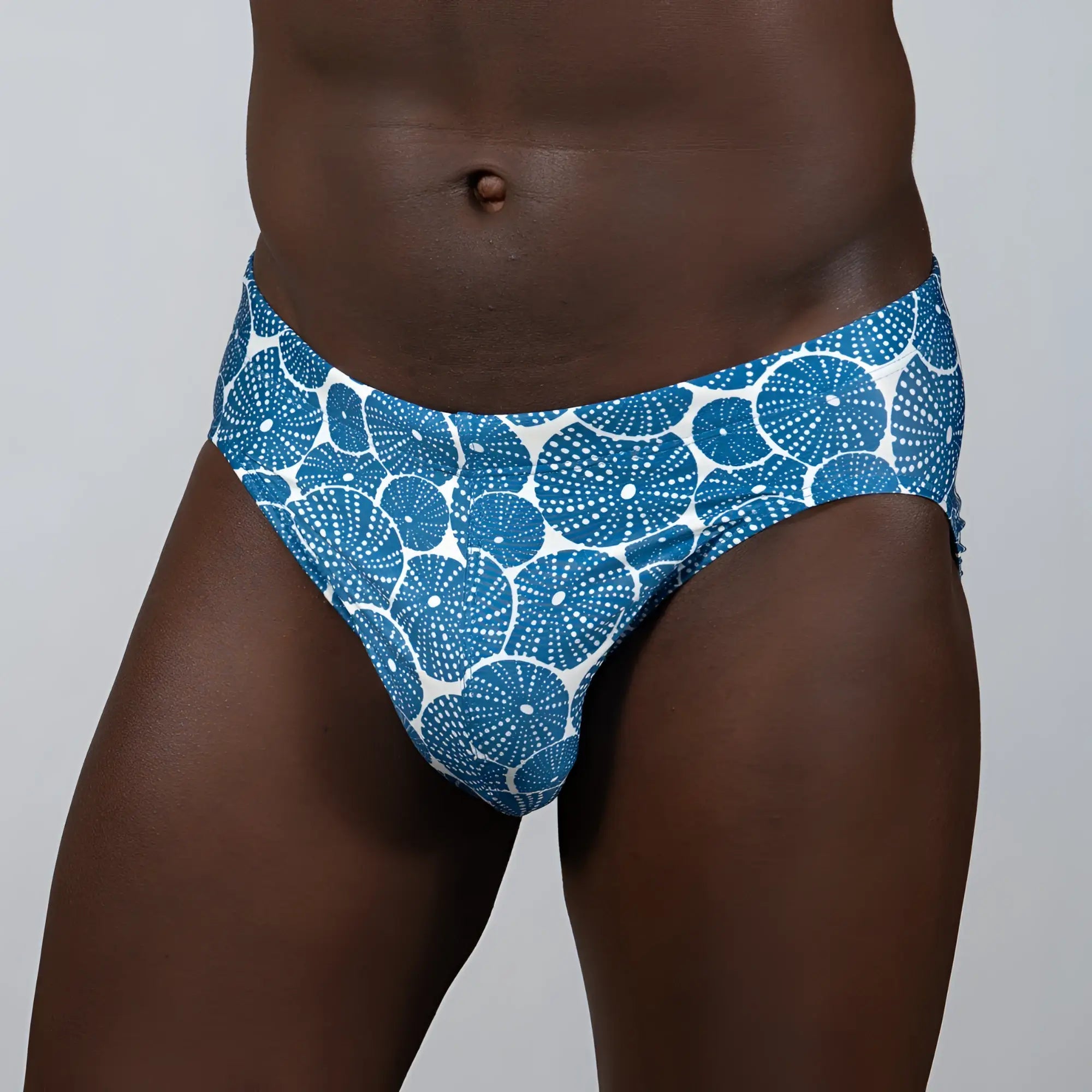 Blue and white patterned swim trunks with circular dotted sand dollar design perfect for beachwear