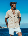 Beige santorini linen short-sleeved button-up shirt with white stitching details for casual wear