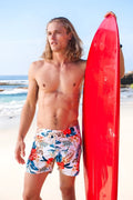 Vibrant red glossy surfboard paired with sauvage laguna boardwalk swim shorts white floral size m