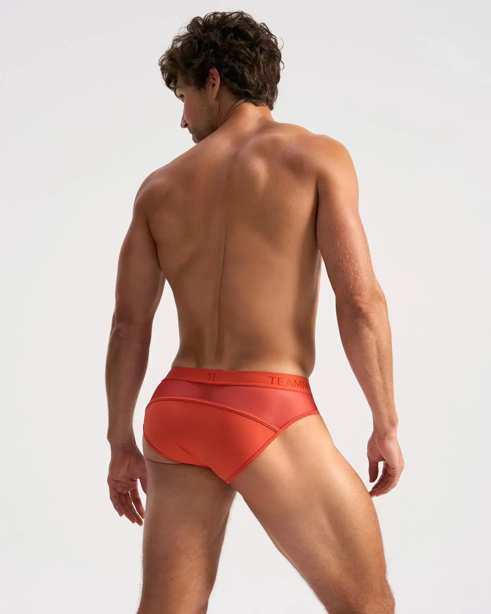 Orange men’s score sheer briefs with subtle textured pattern and team brand name on waistband