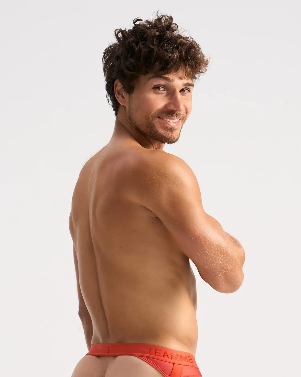 A man wearing bright red calvin klein sheer jock briefs with a visible logo on the waistband front view