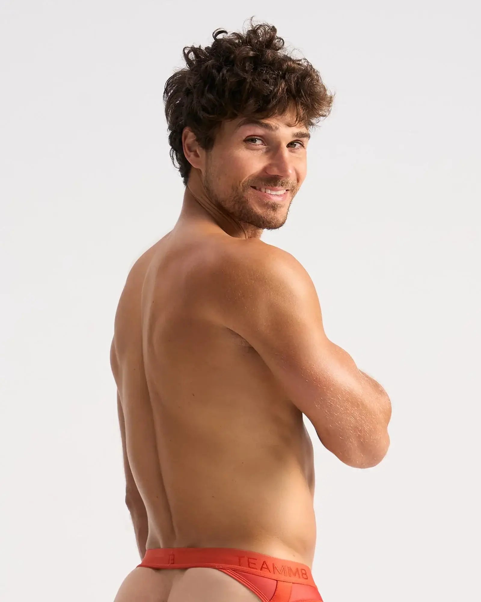 A man wearing bright red calvin klein sheer jock briefs with a visible logo on the waistband front view