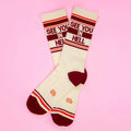 Cream-colored crew socks with maroon and orange stripes and see you in hell bold red lettering on the top cuff