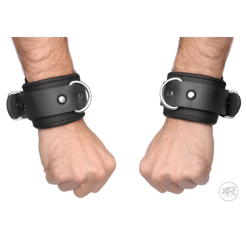 Black leather serve neoprene buckle cuffs with silver-toned metal buckles and d-rings for secure restraint