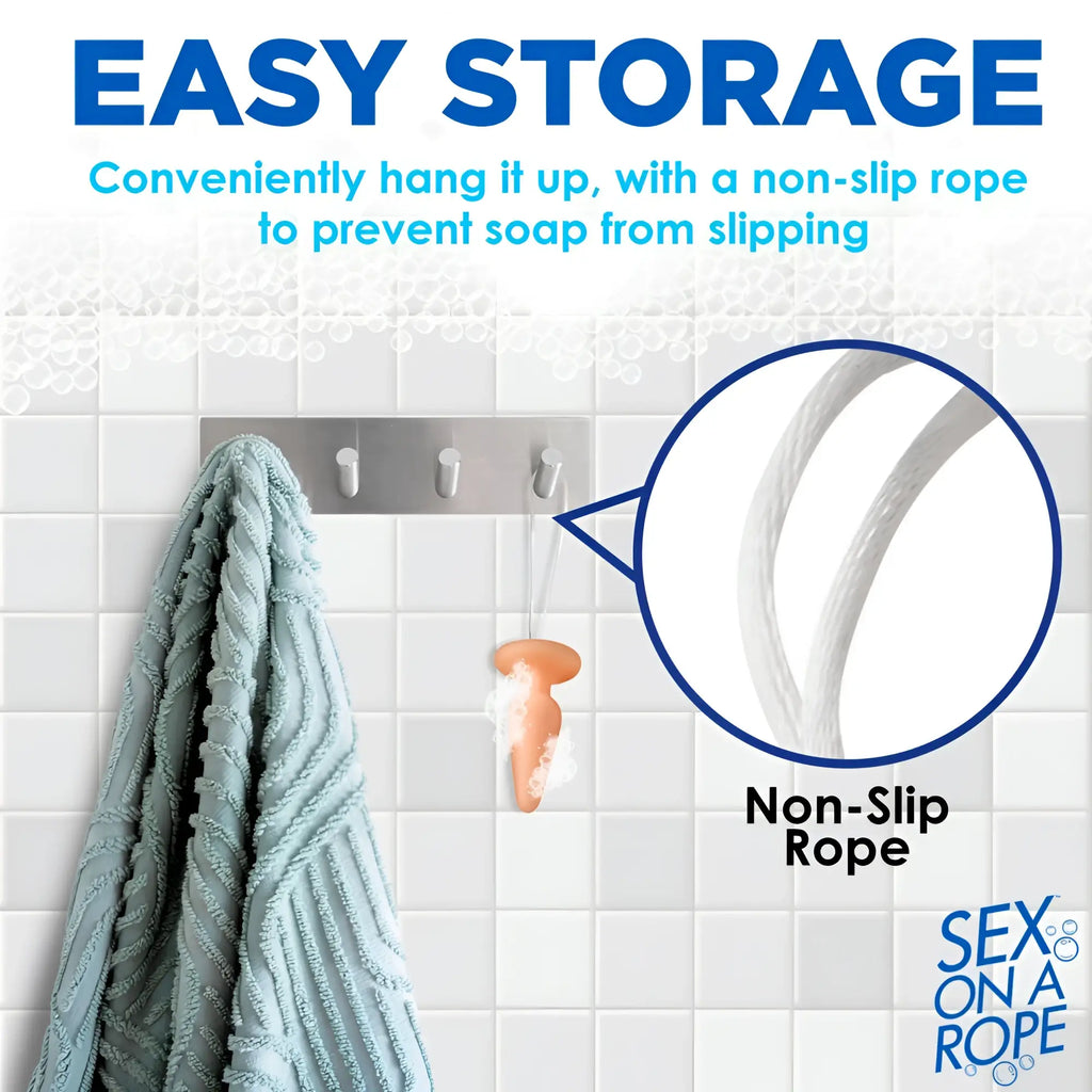 Sex on a Rope soap shaped like a peach-colored butt plug hangs from a shower hook by a white non-slip rope.