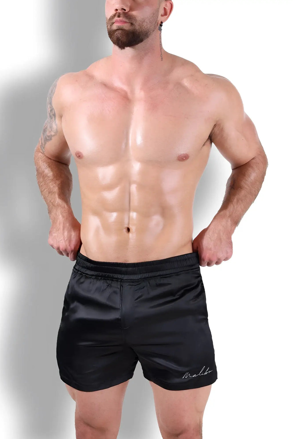 Black satin shimmerflex active shorts with subtle embroidered logo on lower right leg in midnight black