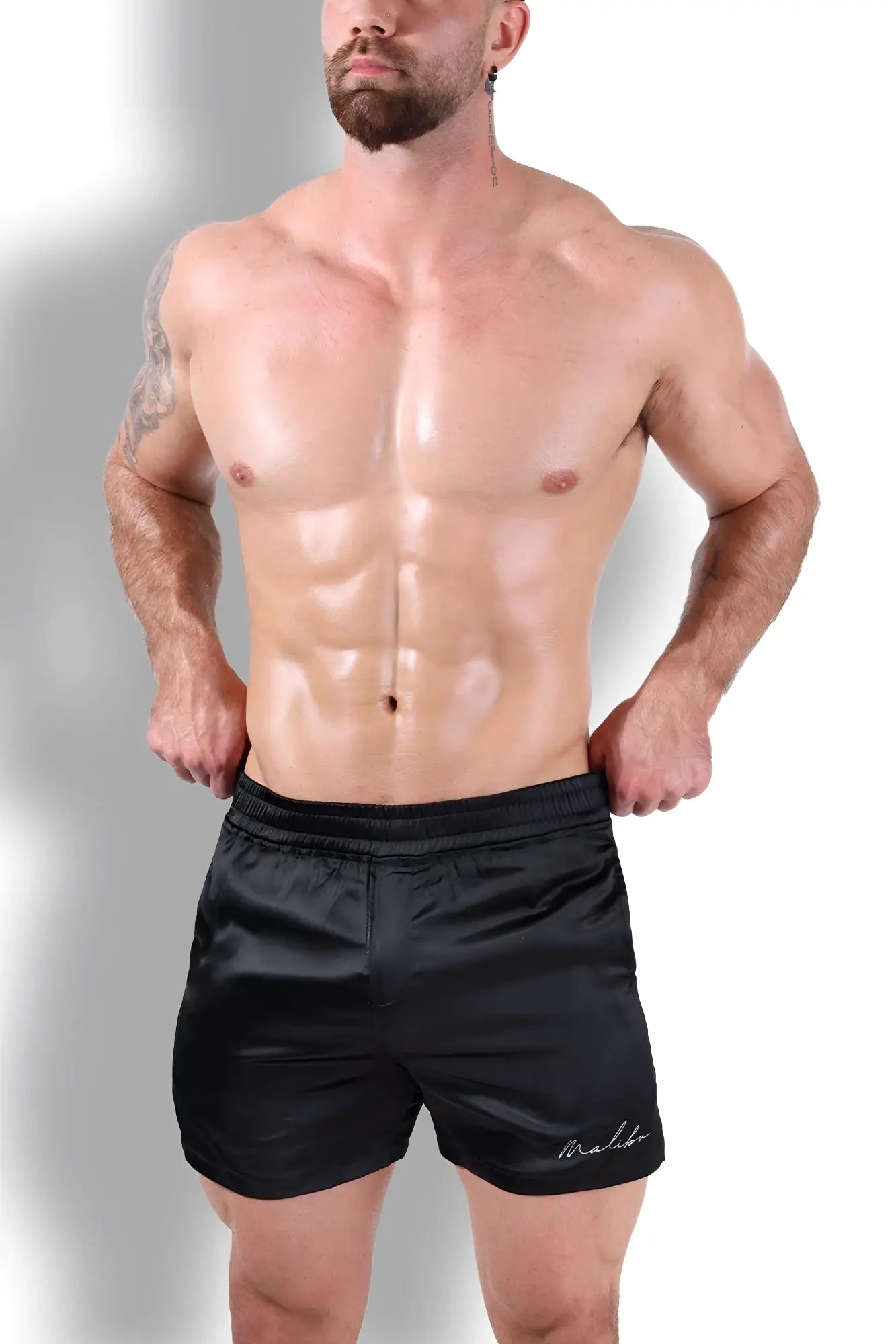 Black satin shimmerflex active shorts with subtle embroidered logo on lower right leg in midnight black