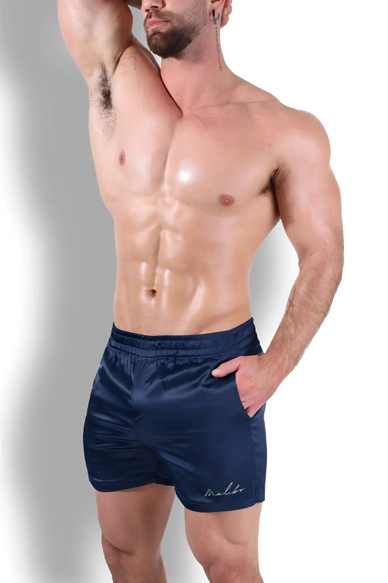 Navy shimmerflex active shorts made of satin with a subtle embroidered logo on the lower right leg