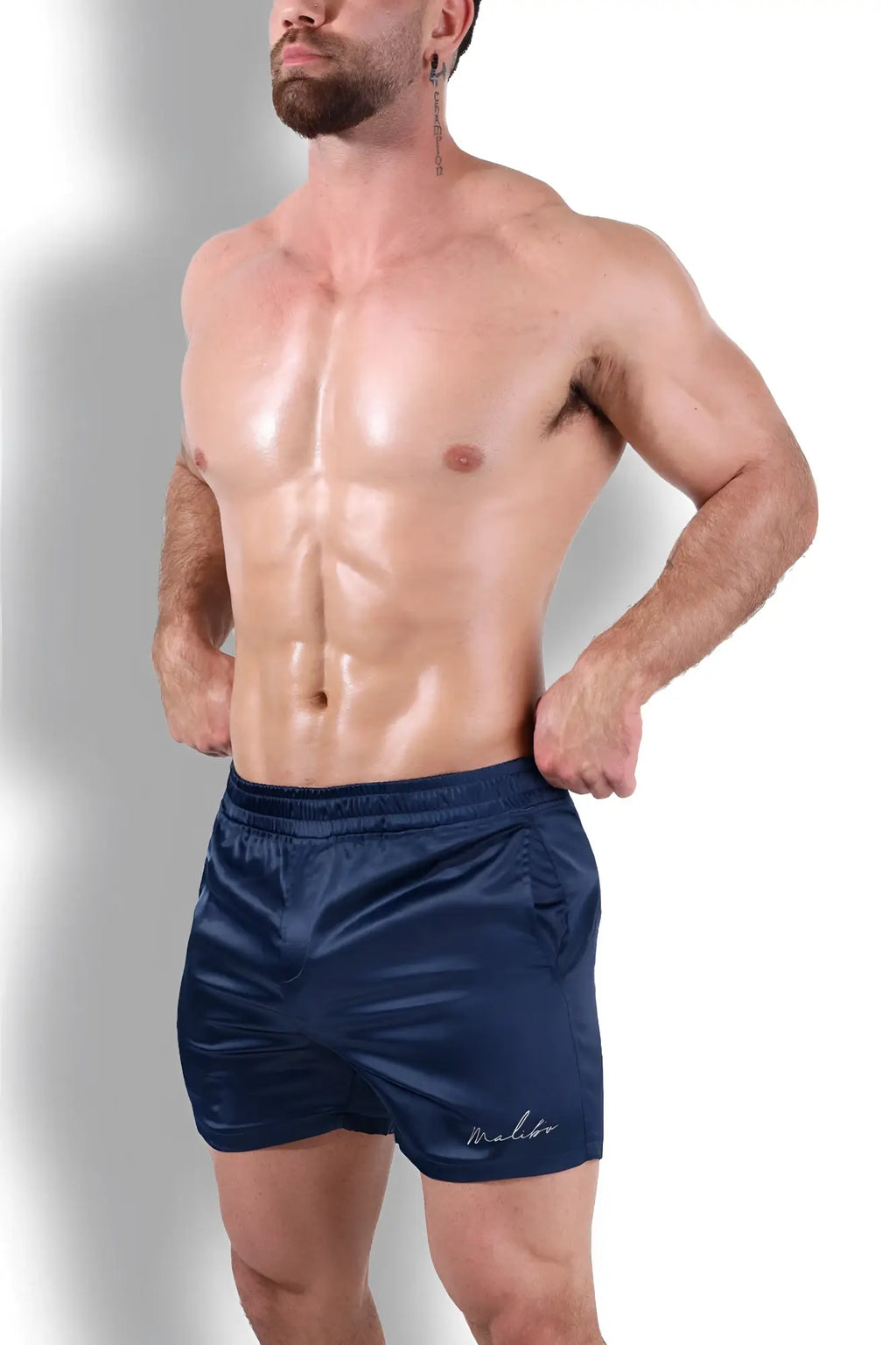 Navy blue satin shimmerflex active shorts featuring a subtle embroidered logo on the lower right leg