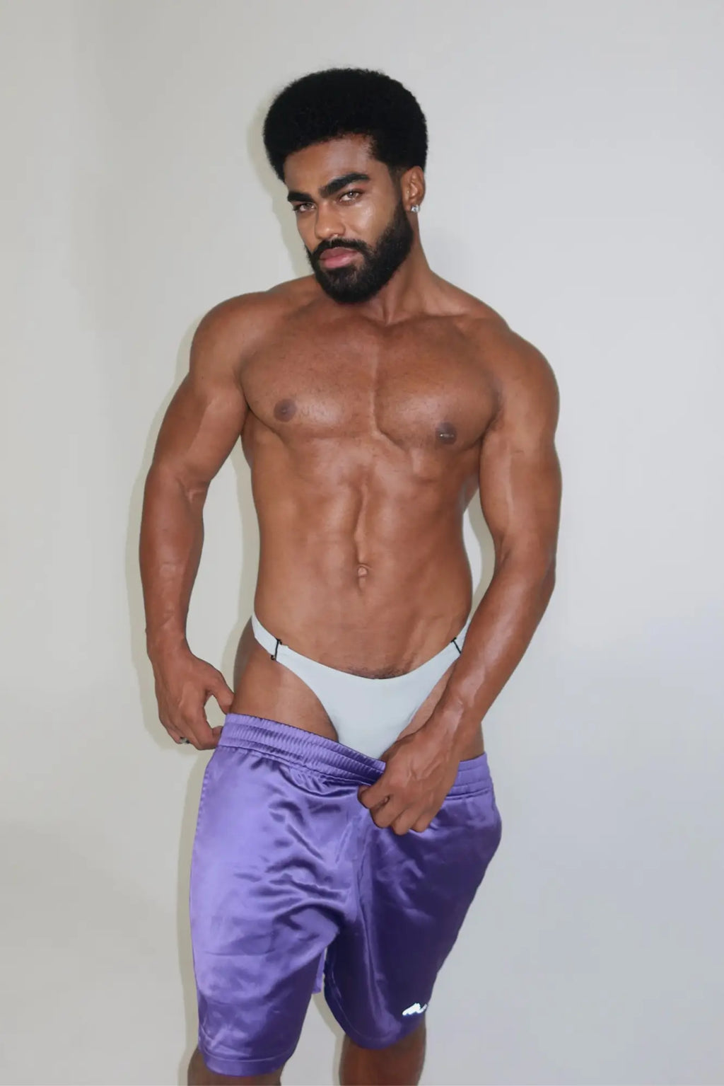 Purple satin shimmerflex active shorts with white trim designed for athletic use