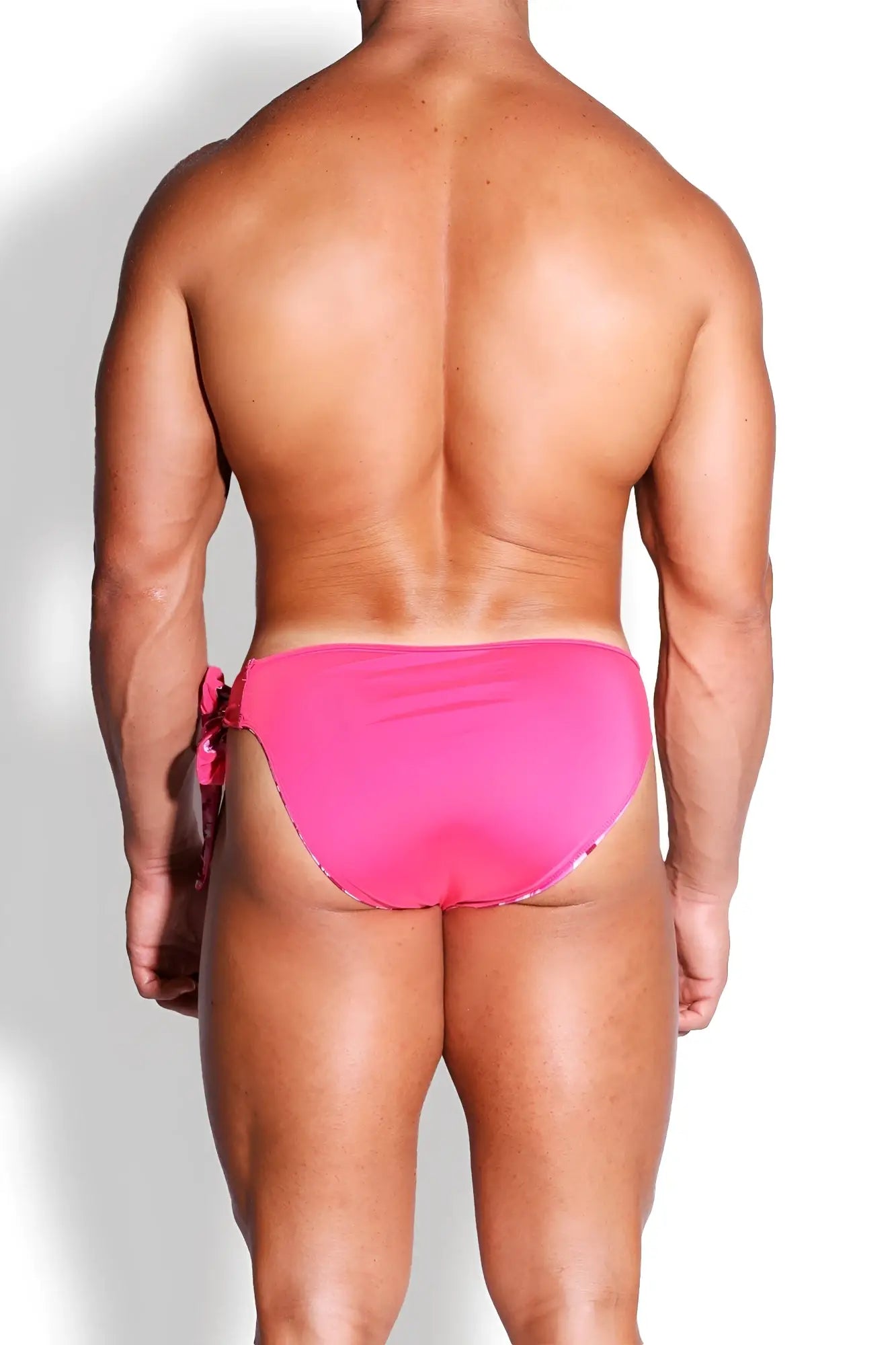Bright pink high-waisted reversible swim briefs with side tie detail for versatile beachwear