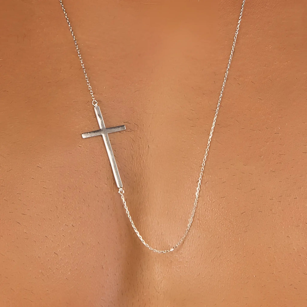 Sideways silver male cross necklace featuring a minimalist silver pendant with a delicate chain