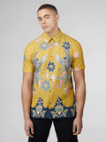 Yellow short-sleeved button-up shirt with intricate blue pink and white floral and bird patterns on dotted background