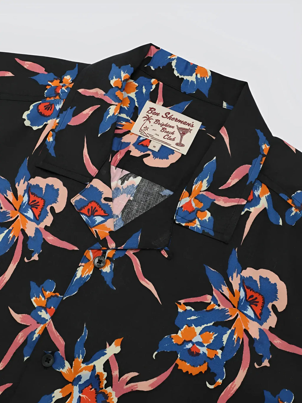 Black button-up shirt with signature botanical print featuring vibrant blue orange and pink floral pattern