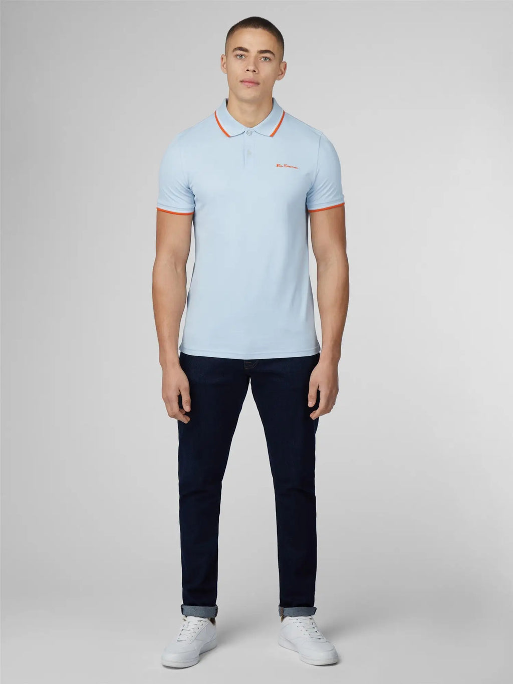 Light blue signature polo shirt with orange trim on collar and cuffs featuring embroidered chest logo
