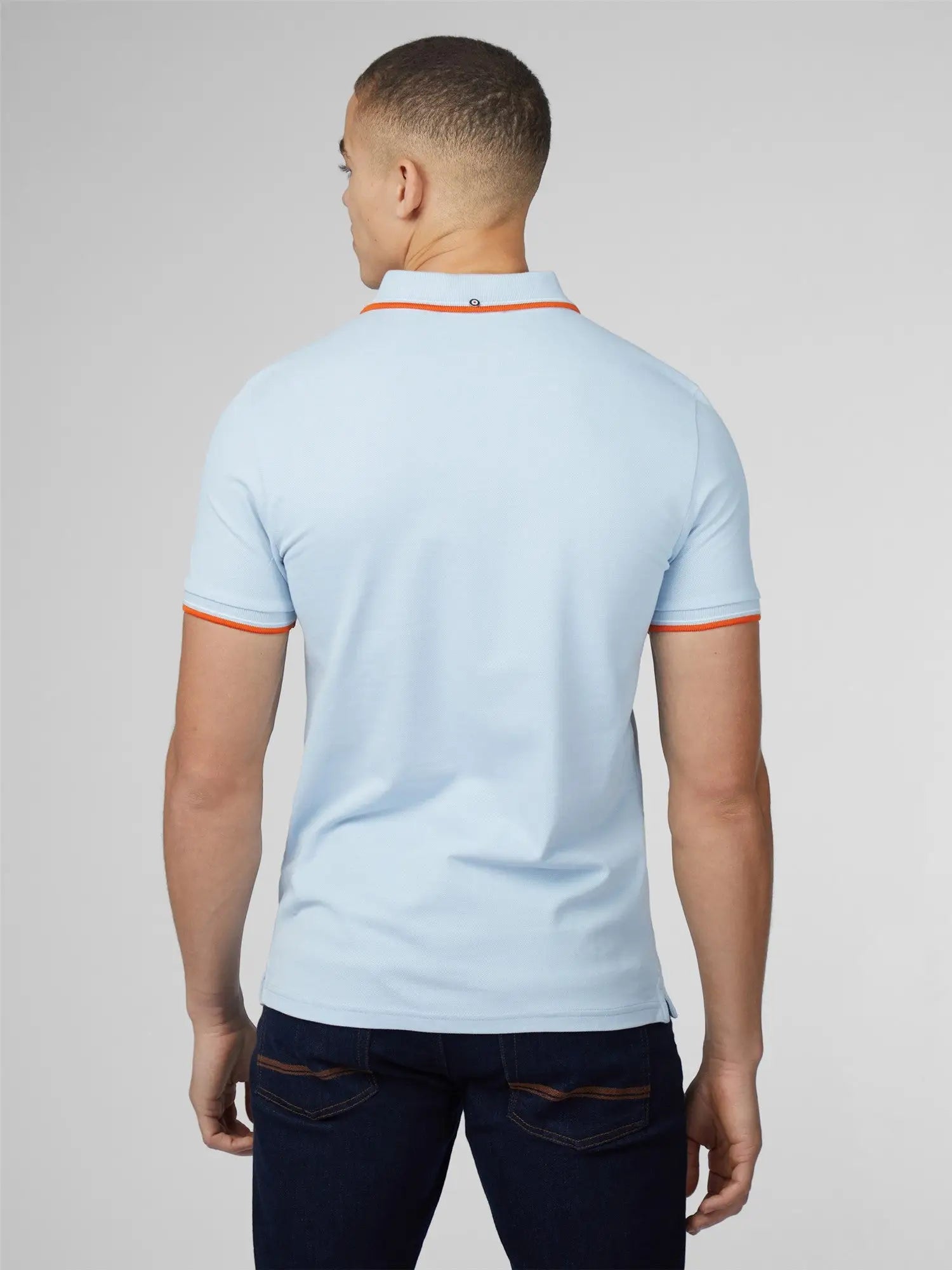 Light blue signature polo shirt with orange trim on collar and sleeve cuffs made of breathable fabric