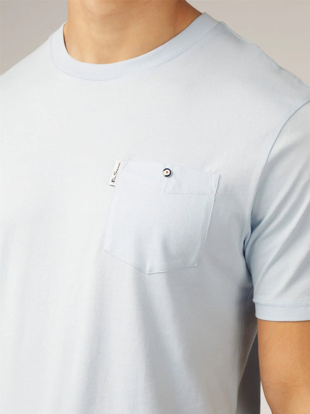 Light blue signature t-shirt with short sleeves and chest pocket featuring a small black and white button closure