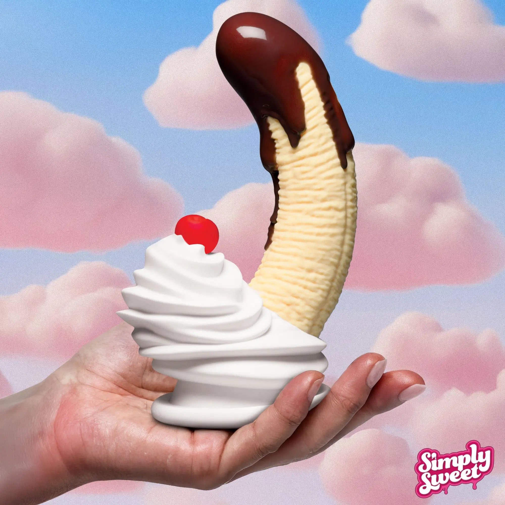 Simply Sweet chocolate-dipped banana split dildo with whipped cream and cherry base, held in a hand against pink clouds.