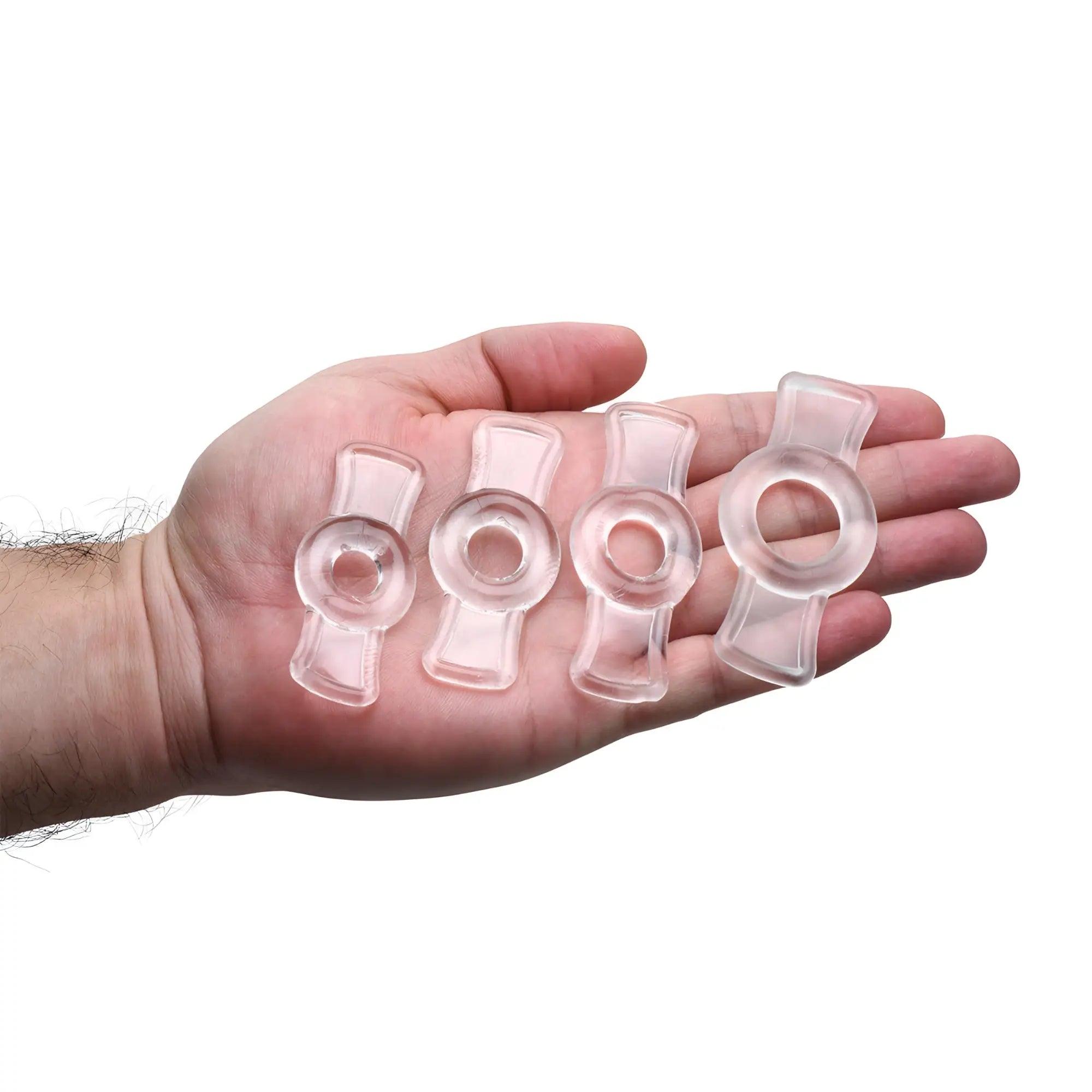 Size Matters The Endurance Penis Ring Set: Four clear, silicone rings of varying sizes held in a palm.