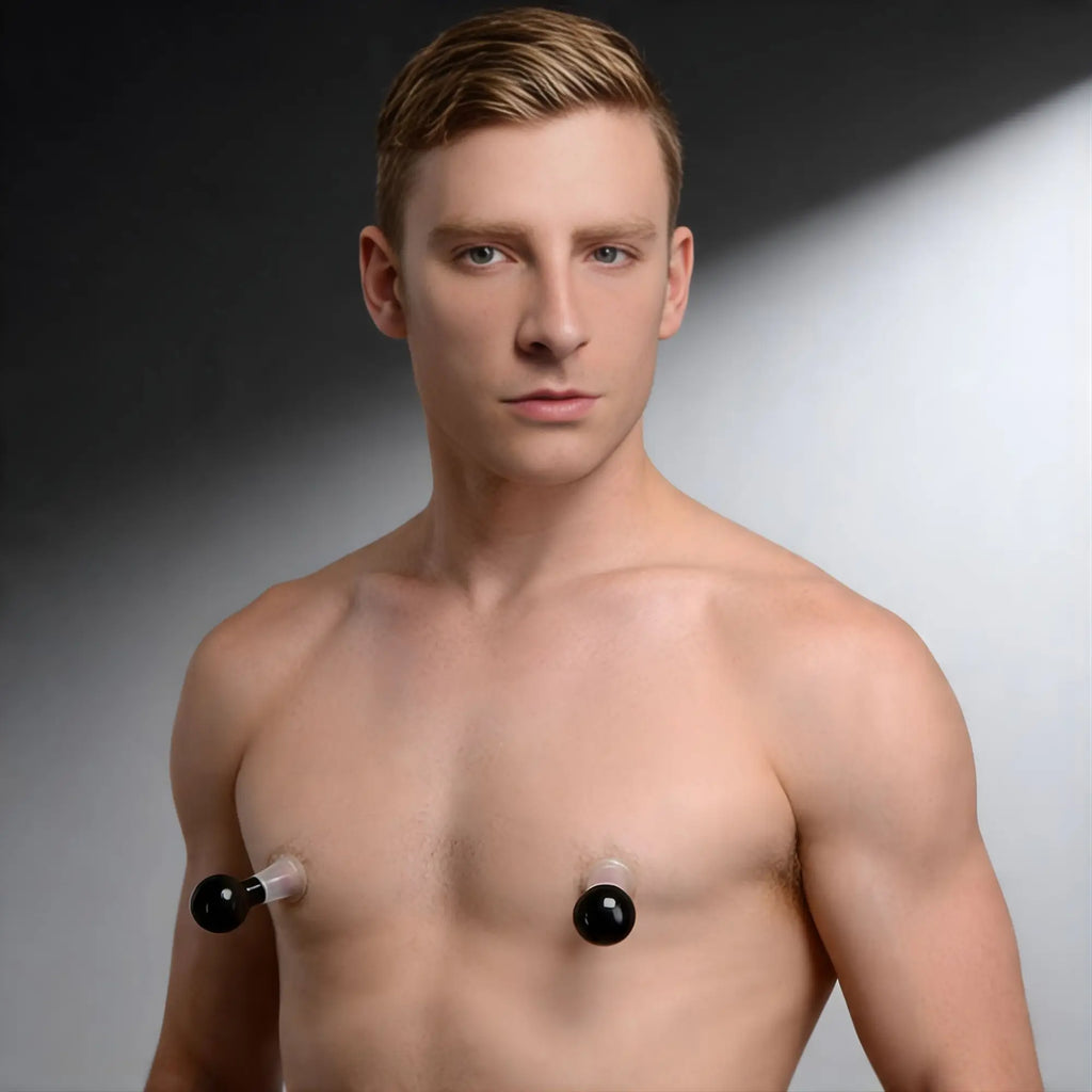A shirtless man wearing clear and black Size Matters See Thru Nipple Boosters on a studio background.