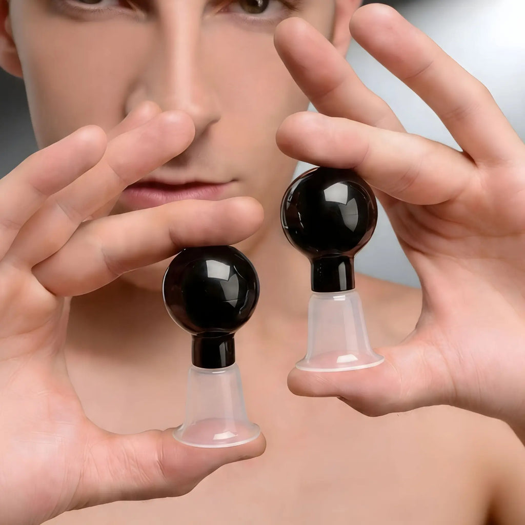 Size Matters See Thru Nipple Boosters: two black bulb suction devices with clear, bell-shaped silicone bases.