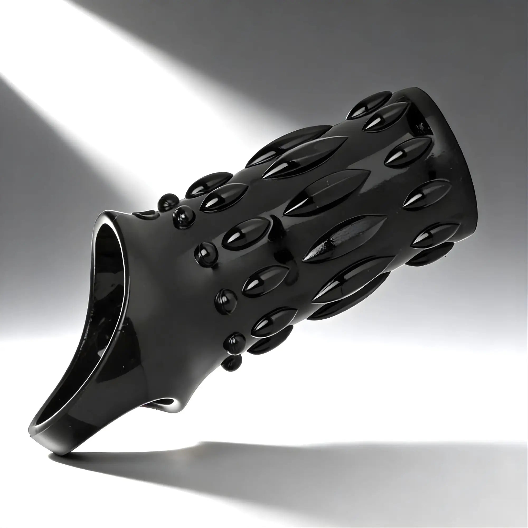 Size Matters Sheath Sensations Enhancer: A glossy black textured sleeve with raised, almond-shaped nodules.