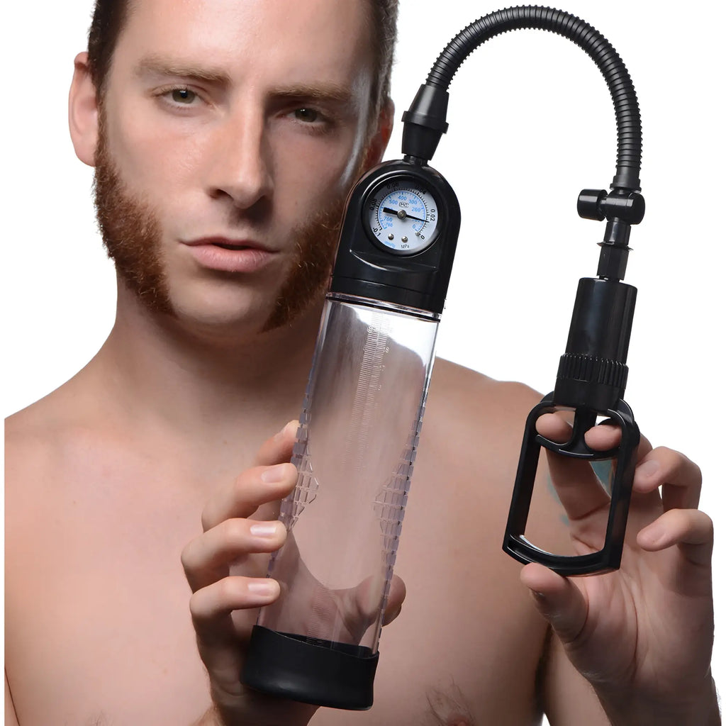 A man holds a clear Size Matters trigger penis pump with a black handle, hose, and built-in pressure gauge.