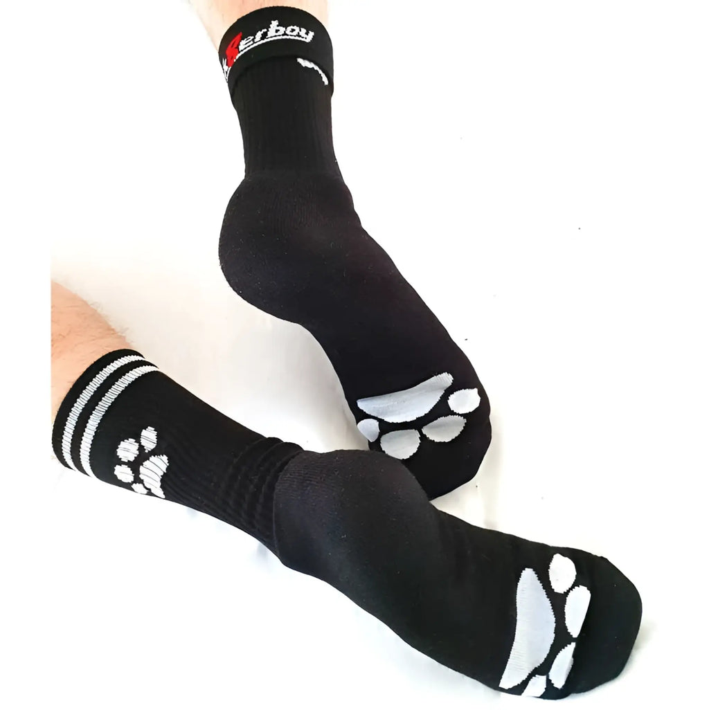 Black sk8erboy puppy socks size 39-42 with white paw prints on soles and stripes near cuffs shown from back side