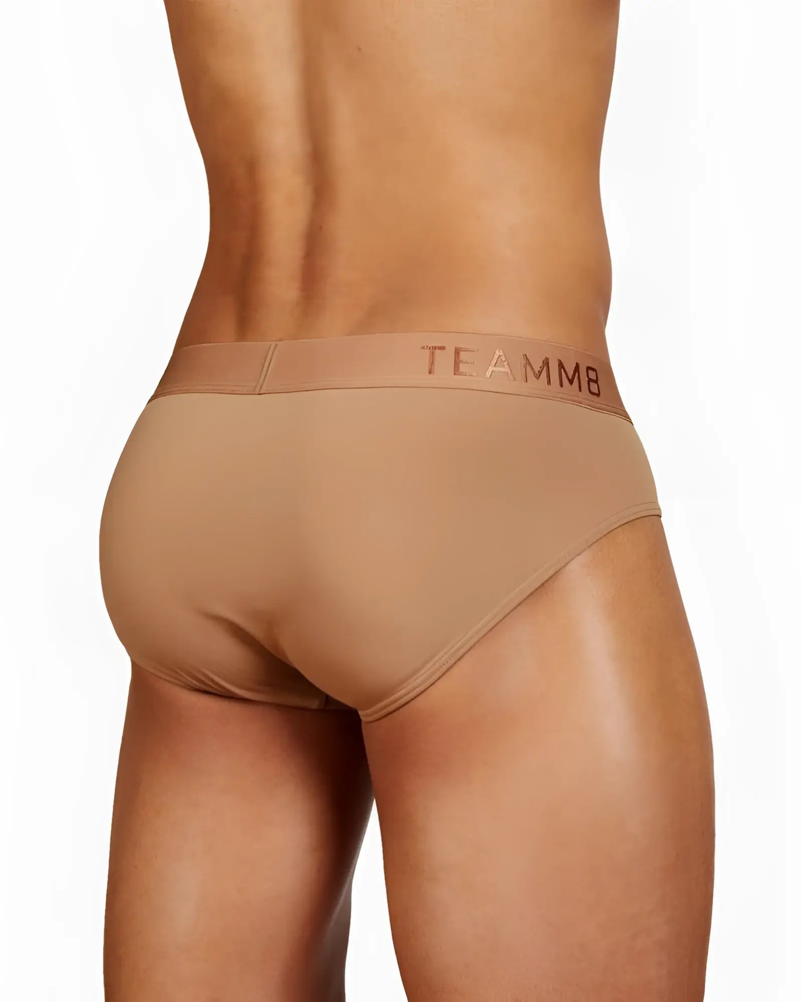 Tan skin brief with a subtle gold logo on the waistband showing the front design of the teammb briefs