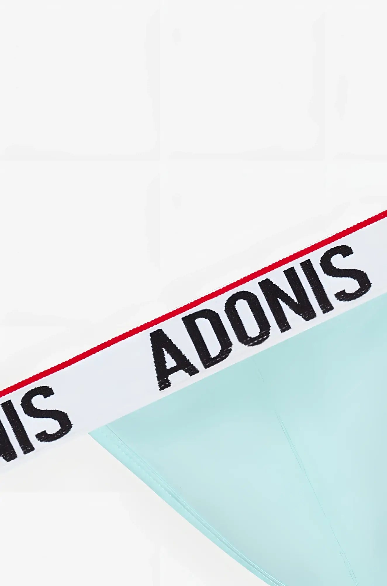 Mint green sky blue thong with white waistband featuring bold black adonis lettering and red trim visible on front side