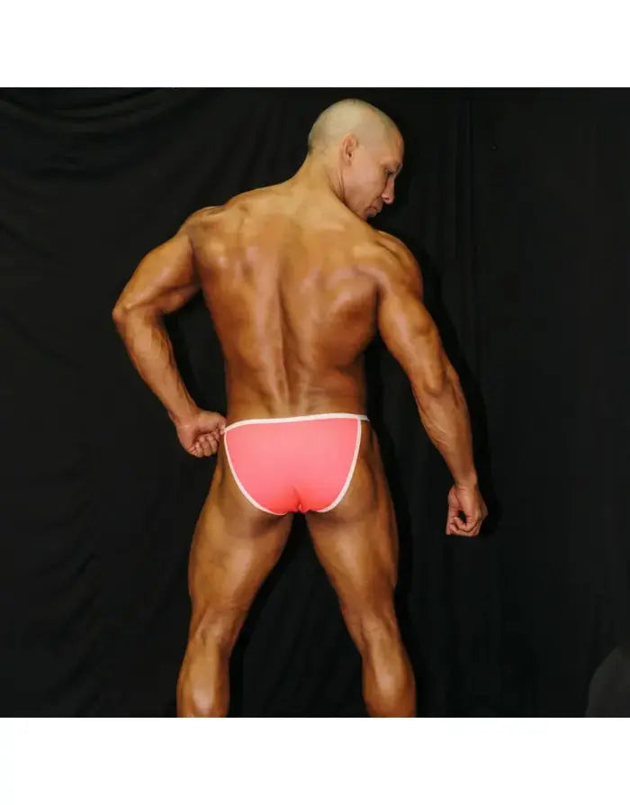 Neon pink men's bikini underwear with white trim shown on a model from the back by Arroyman.