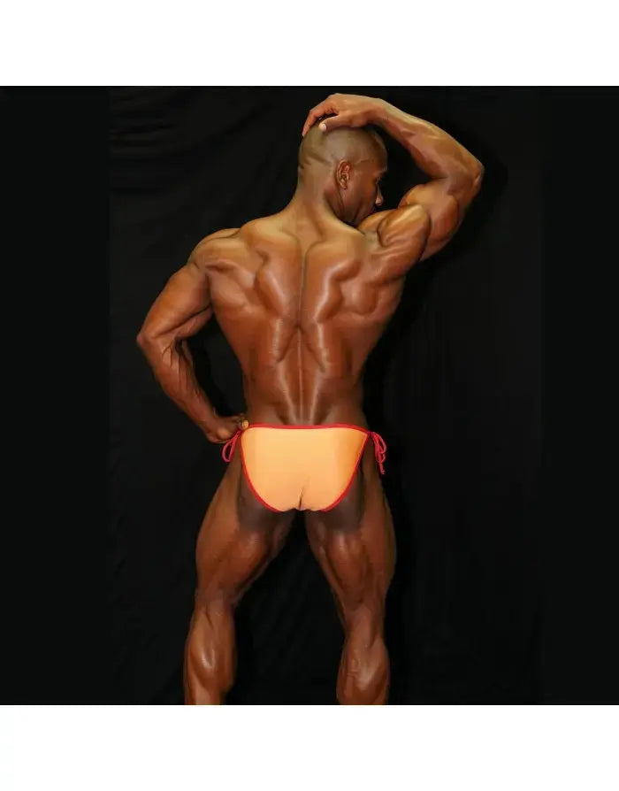 Orange and red sling bikini underwear by Arroyman featuring a low-rise cut and adjustable side ties shown on a muscular model.
