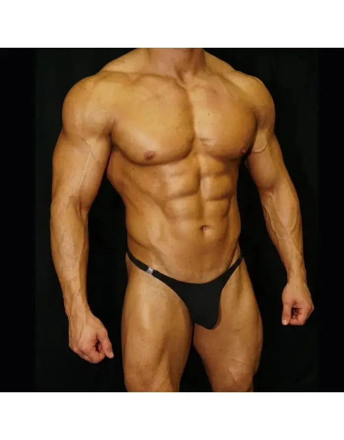 Black thong underwear with buckle detail made by Arroyman shown on a muscular male model against a dark background.