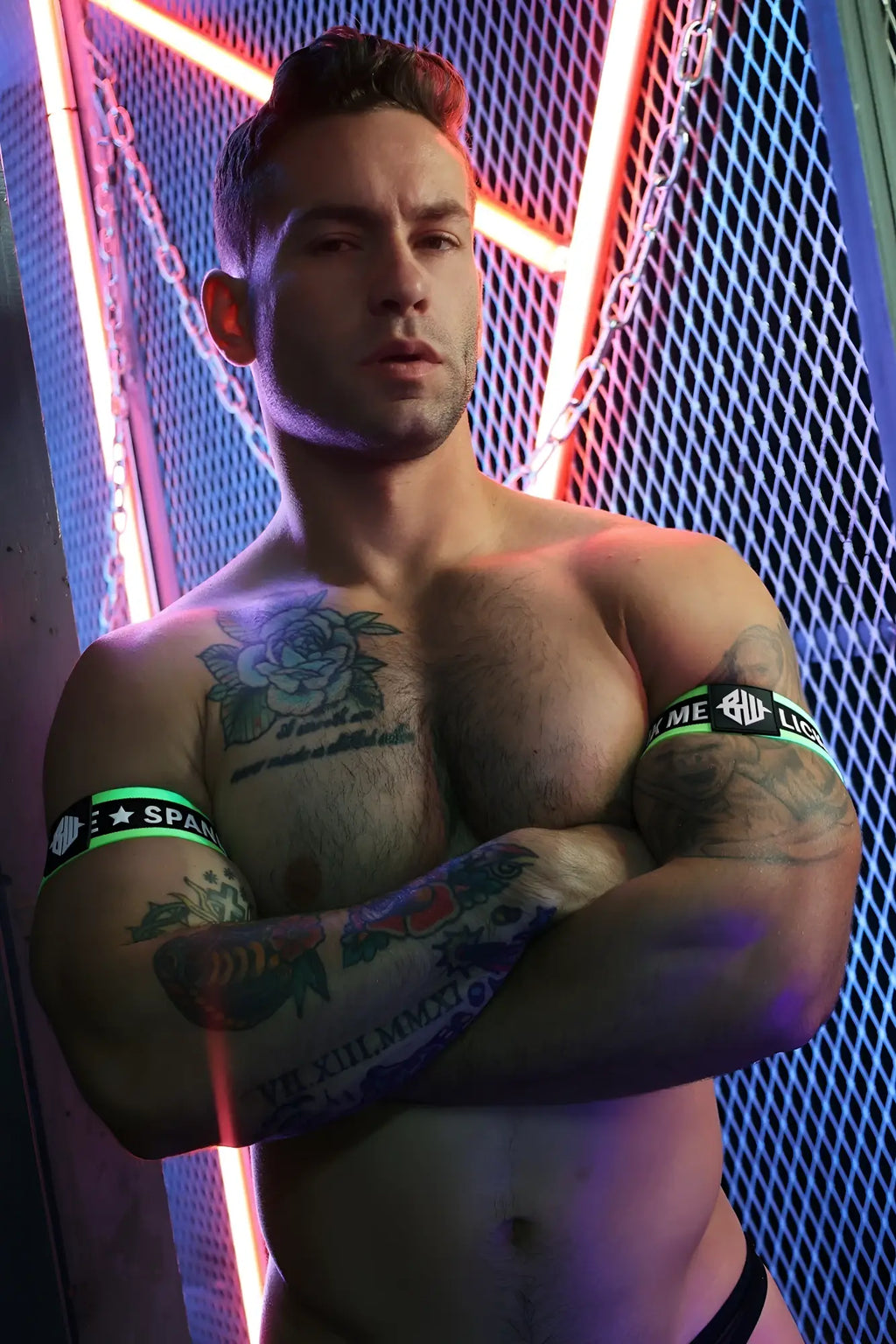 Muscular arms wearing black and neon green snax armbands with white text and logo for athletic use