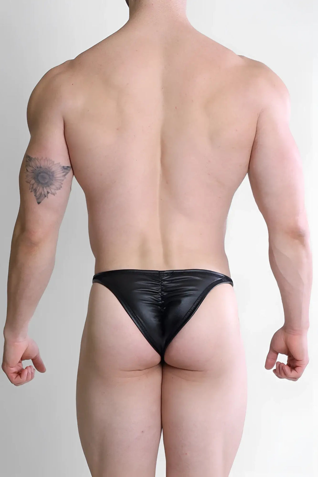 Black liquorice soft vegan leather scrunch-butt briefs showing the back in a smooth shiny thong style