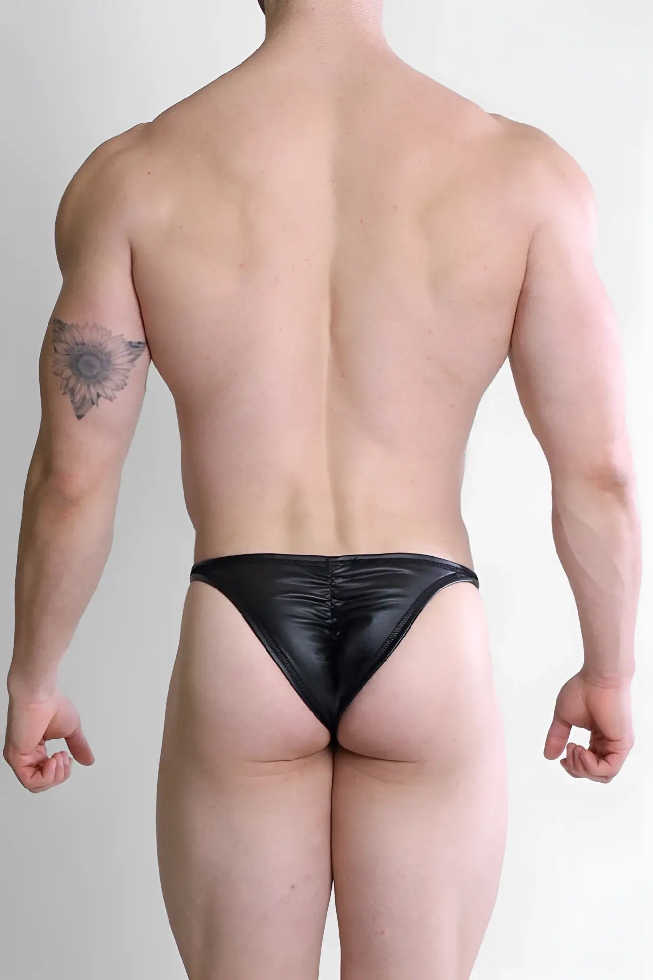 Black liquorice soft vegan leather scrunch-butt briefs showing the back in a smooth shiny thong style