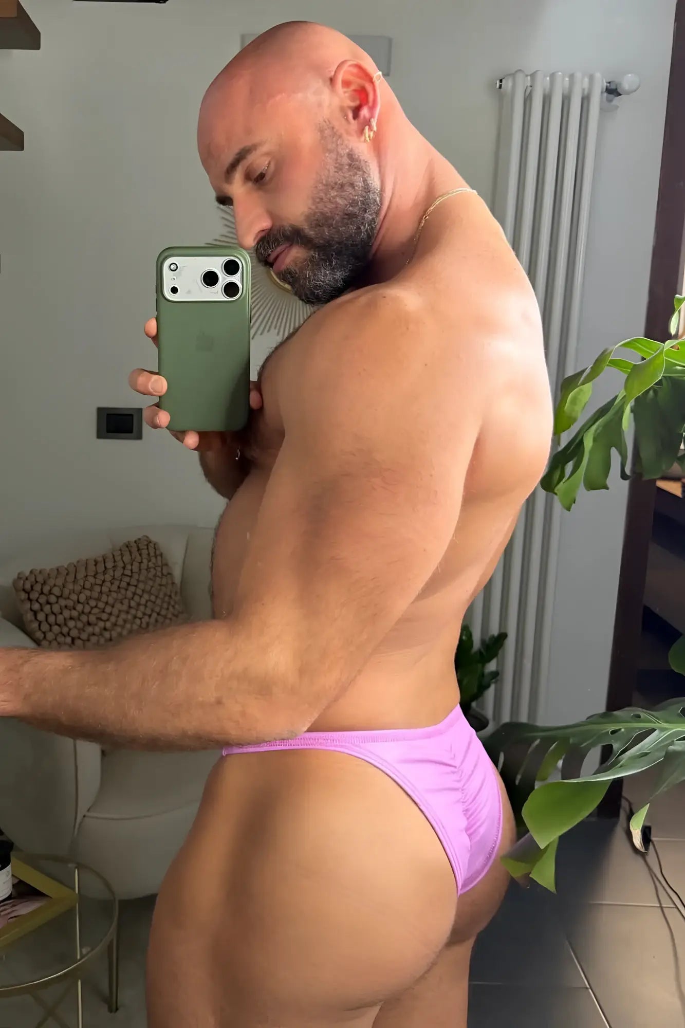 A man wearing vibrant purple soft vegan leather scrunch-butt briefs showing the back side of the product